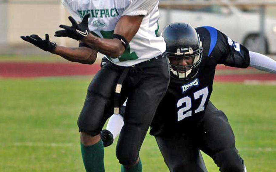 Joint Task Force Wolfpack receiver Sharome Cook hauls in a pass in front of Kadena Dragons defensive back Harold Mears (27) during Saturday's U.S. Forces Japan-American Football League South Division first-round playoff game at Camp Foster, Okinawa.