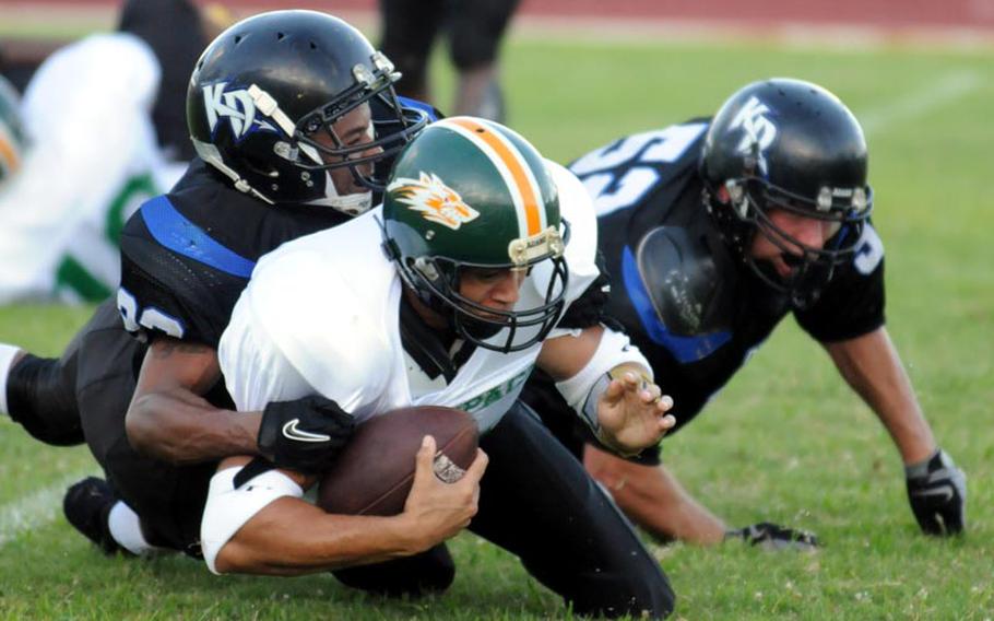 Joint Task Force Wolfpack quarterback James Fulz gets brought to the turf by Kadena Dragons defenders Jeremy Brown and Brian Walser during Saturday's U.S. Forces Japan-American Football League South Division first-round playoff game.