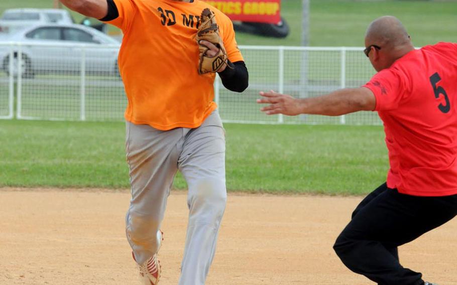 Second baseman Francisco Poo of 3rd Marine Logistics erases Marine Corps Base Camp S.D. Butler runner Jesse Segura and makes the relay throw to first base during Friday&#39;s championship-bracket final game in the double-elimination playoffs in the 2011 Marine Corps Far East Regional Softball Tournament at Field 1, Gunners Fitness & Sports Complex, Camp Foster, Okinawa. 3rd MLG won 7-6 in nine innings, then beat Base again 11-9 in Friday&#39; evening&#39;s championship game, winning the title for the second straight year.