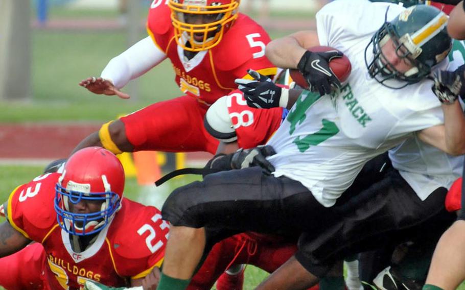 Joint Task Force Wolfpack running back Andrew Majors (41) slithers out of the tackle of Foster Bulldogs defenders Josh Reed (23), Lucas Gisten (5) and Royce Platt (28) during Saturday's U.S. Forces Japan-American Football League South Division title game at Camp Foster, Okinawa. Foster won 26-6 and earned a berth in Saturday&#39;s Torii Bowl at Misawa Air Base, northern Japan, where the Jets won the North Division title 21-14 over the defending champion Yokota Warriors.