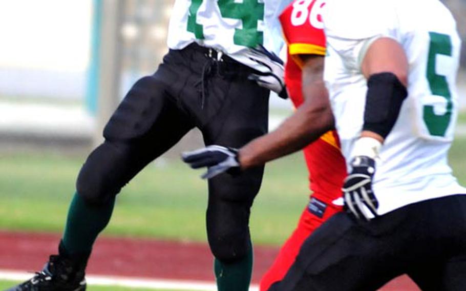 Joint Task Force Wolfpack defensive back John Butler (14) comes down with an interception of a pass intended for Foster Bulldogs receiver Corey Moore (86) as Wolfpack teammate Yohan Silva (5) watches during Saturday's U.S. Forces Japan-American Football League South Division title game.