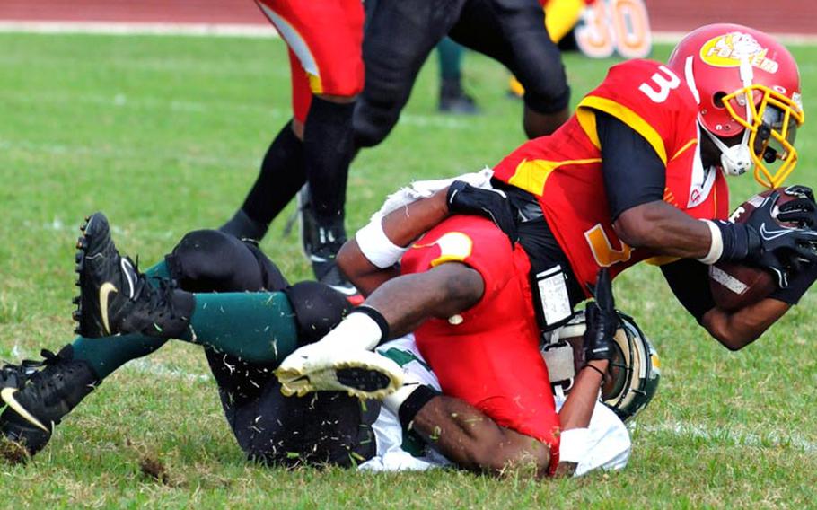 Foster Bulldogs running back Nekory Moorer (3) is tackled by Joint Task Force Wolfpack defender John Butler during Saturday's U.S. Forces Japan-American Football League South Division title game.