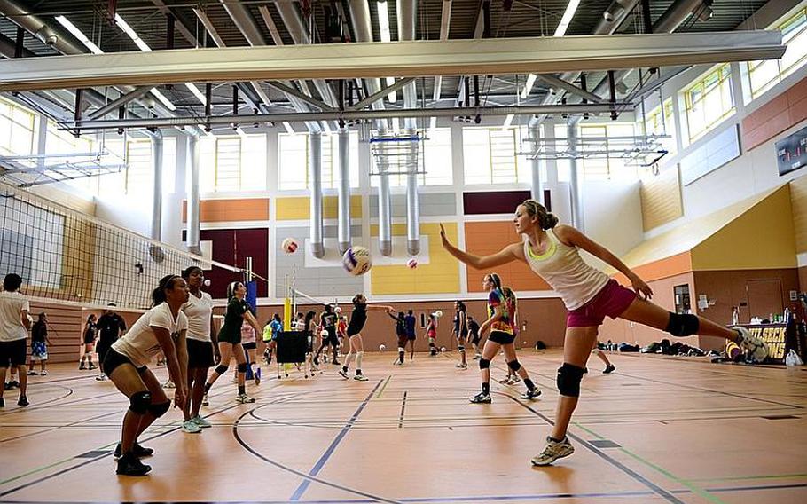 Abby Diaz, 17, and Rachel Hutchinson, 17, seniors from Patch High School, Stuttgart, Germany, practice a drill Monday at this year's DODDS-Europe volleyball camp at Vilseck High School.