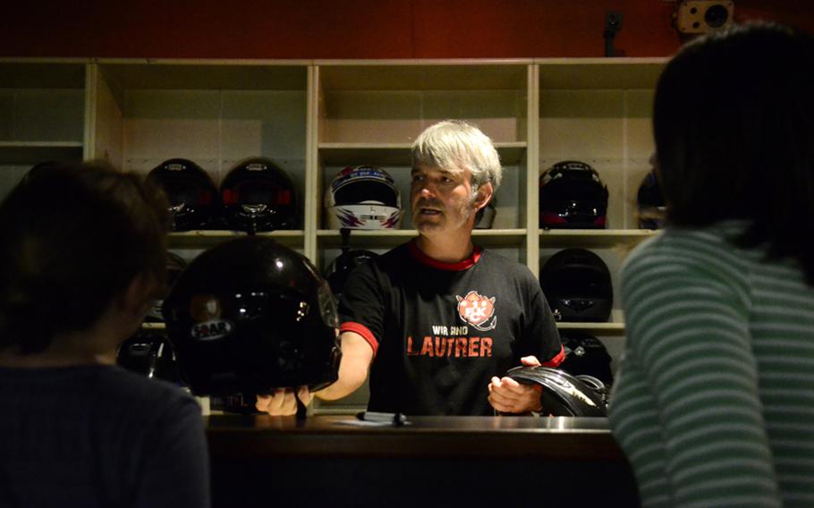 Gerald Conrad, co-owner of Go! Indoor-Kart, hands out helmets to customers before they get behind the wheel.
