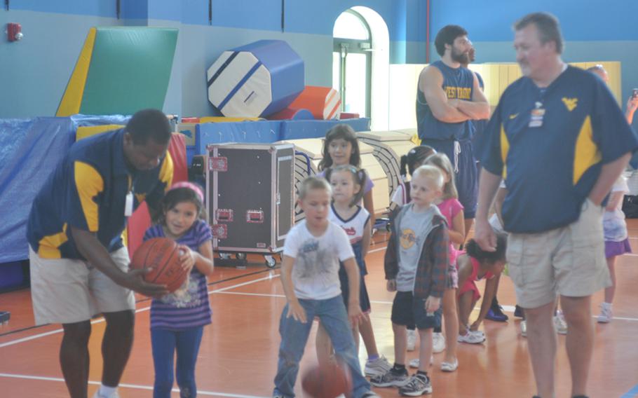 West Virginia head coach Bob Huggins, right, watches associate head coach Larry Harrison direct a line of base kids during a clinic Wednesday put on by coaches and players of West Virginia and Illinois at Aviano Air Base, Italy.