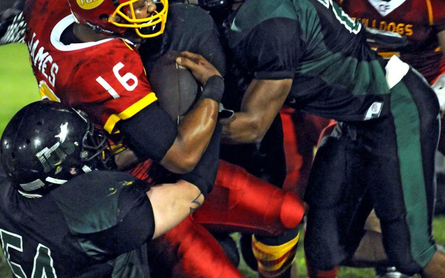 Foster Bulldogs quarterback James Sanford is brought down by Misawa Jets defenders Michael Rohde and Reed Merriwether during Saturday's Torii Bowl league title game at  Misawa Air Base, Japan. The Bulldogs rallied from a 20-2 deficit to beat the Misawa Jets 24-20, the first road victory in Torii Bowl history and the second USFJ-AFL title for Foster in three seasons.