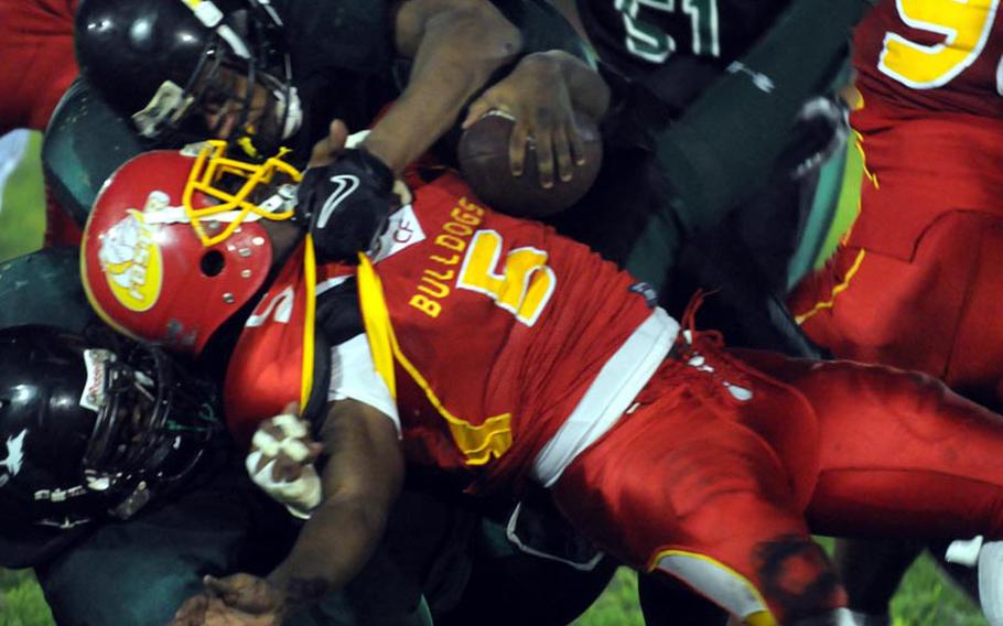 Foster Bulldogs running back Damian Peterson is wrestled down by two Misawa Jets defenders during Saturday's Torii Bowl league title game at Misawa Air Base, Japan. The Bulldogs rallied from a 20-2 deficit to beat the Misawa Jets 24-20, the first road victory in Torii Bowl history and the second USFJ-AFL title for Foster in three seasons.