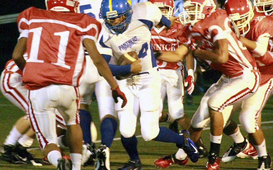 Yokota Panthers running back Raymond Butler is surrounded by Nile C. Kinnick Red Devils defenders during Friday's DODDS-Japan/Kanto Plain high school football game at Yokosuka Naval Base, Japan. Yokota blanked Kinnick 34-0.