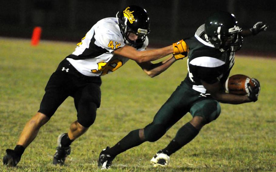 Kadena Panthers defender Josh Garick grabs Kubasaki Dragons running back Jarrett Mitchell by the jersey during Friday's Okinawa Activities Council high school football game at Kubasaki High School, Okinawa. Kadena won 15-14.