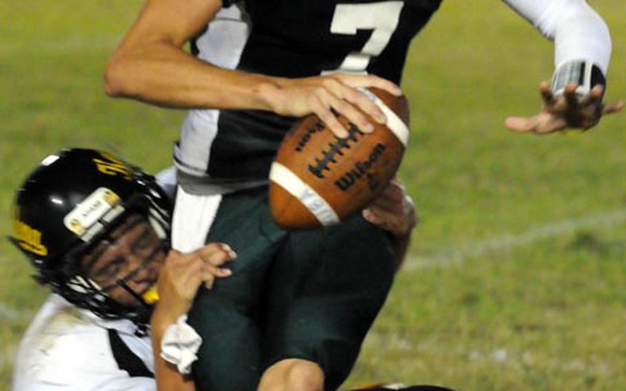 Kubasaki Dragons quarterback Cristian Rivera tries to shake free from the tackle of Kadena Panthers defender Gage Bongo during Friday's Okinawa Activities Council high school football game at Kubasaki High School, Okinawa. Kadena won 15-14.