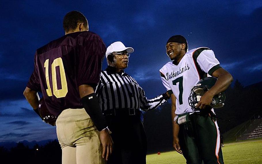 Ben McDaniels of Baumholder and J. D. Pollock of AFNORTH, meet with referee Tomas Villegas Jr. just before the second half of play Friday night at  Baumholder, Germany.