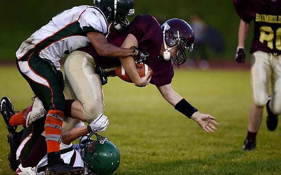 Christian Kubas, a sophomore quarterback for Baumholder, is tackled by two AFNORTH players, Friday night at Baumholder, Germany.