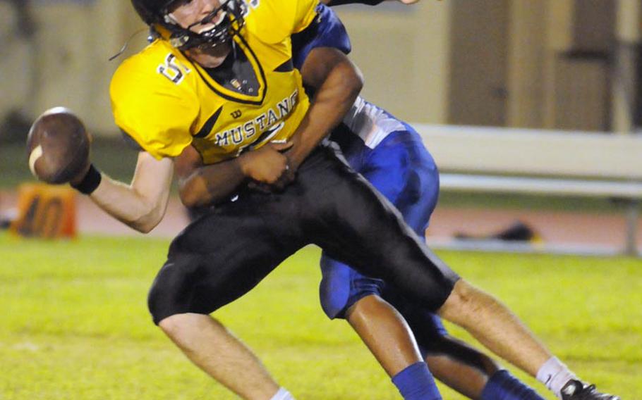 American School in Japan Mustangs quarterback Hayden Jardine looks for someone to throw to before being sacked for a 15-yard loss by Yokota Panthers linebacker Phillip Burnett during Friday's Kanto Plain Association of Secondary Schools football game at Yokota High School, Japan. Yokota won 41-20.