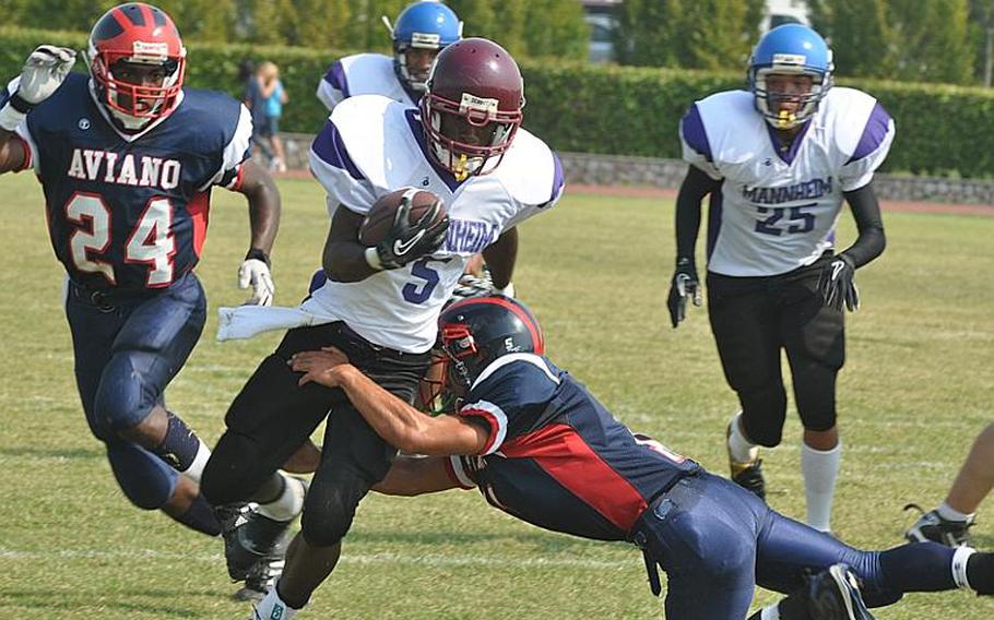 Schweinfurt running back Devontay Collier shrugs off the tackle of Aviano's Nik Weisner to pick up some yardage Saturday in his school's first ever football game. Collier, a junior, ran for 120 yards, but the Razobacks lost to the Saints, 37-7.