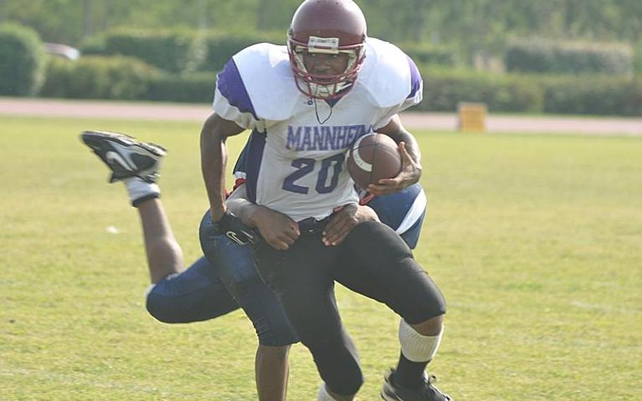 Schweinfurt running back Tony Price is slowed down by Aviano defender Elijah Smith Saturday in the Saints' 37-7 victory over the Razorbacks in Schwinfurt's football debut.