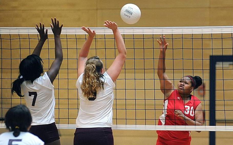 Kaiserslauterns Kalynn Richardson, right, knocks the ball back over the net against Baumholder's Joella Milledge, left, and Charlee Schroeder. The two teams won one a game apiece at the jamboree in Wiesbaden, on Saturday. Baumholder took the first game 25-19 and dropped the second 24-20 in the 35-minute match.
