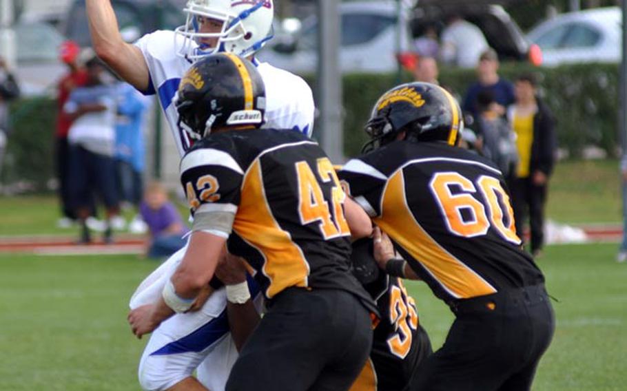 Ramstein quarterback Steven Groenheim dumps the ball out of bounds to prevent losing yards as he is tackled by three  Patch defenders during Patch's 26 -12 victory Saturday.