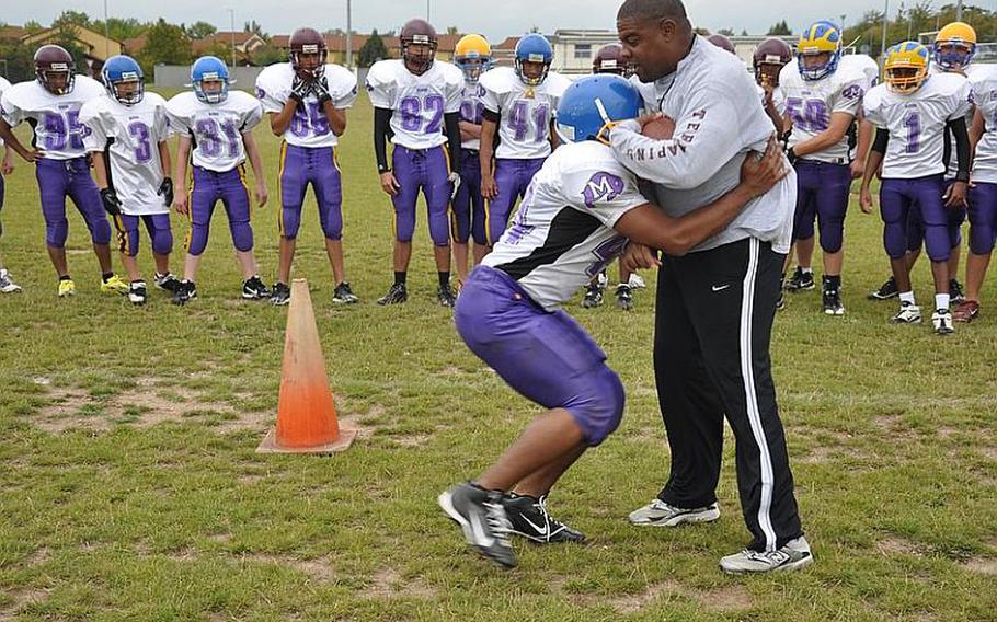 Schweinfurt High School football coach Travis Reynolds demonstrates a drill with sophomore Josh Richardson during a recent practice in Schweinfurt.