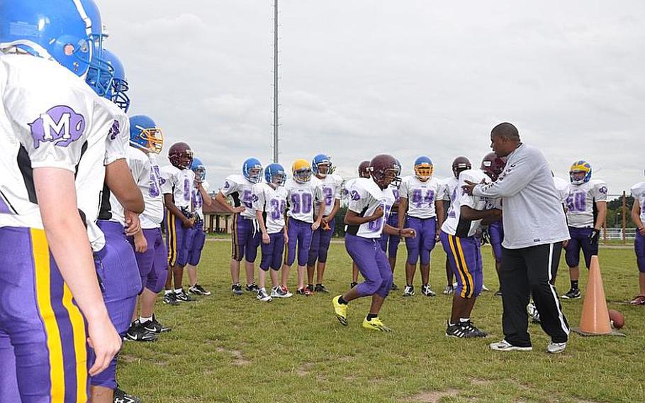 Schweinfurt High School football coach Travis Reynolds goes through a drill with his team during a recent practice in Schweinfurt.