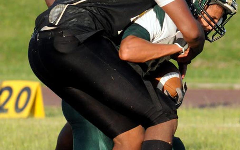 Kadena Panthers defender Josh Dyer tackles Kubasaki Dragons running back Jace Johnson during Friday's Okinawa Activities Council football game at Kadena High School, Okinawa. Kubasaki won 13-0.