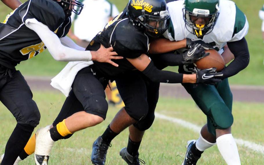 Kubasaki Dragons running back Jarrett Mitchell gets run down by Kadena Panthers defenders Josh Dyer, Joey Dyer and Christopher McQuillan during Friday's Okinawa Activities Council football game at Kadena High School, Okinawa. 