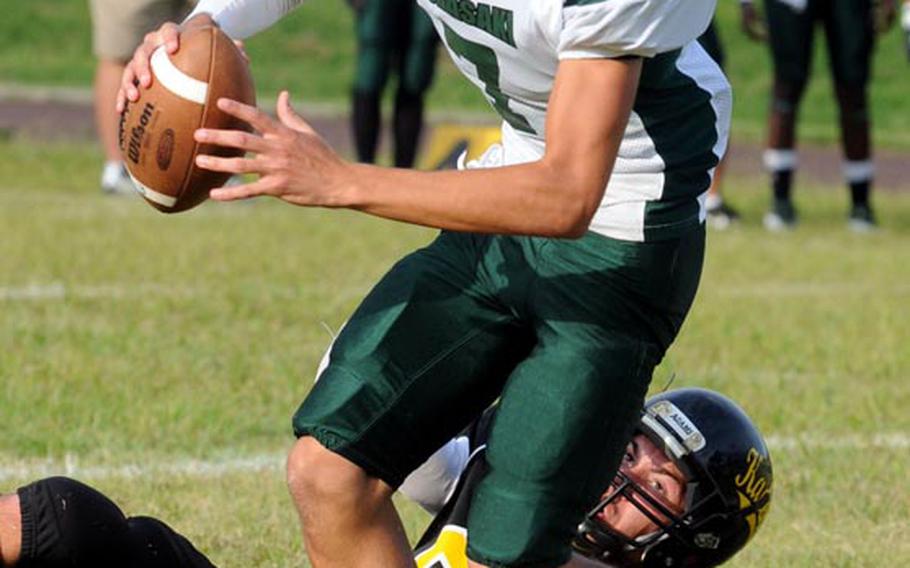 Kubasaki Dragons quarterback Cristian Rivera frees himself from the grasp of Kadena Panthers defender Chris McQuillan during Friday's Okinawa Activities Council football game at Kadena High School,  Okinawa.