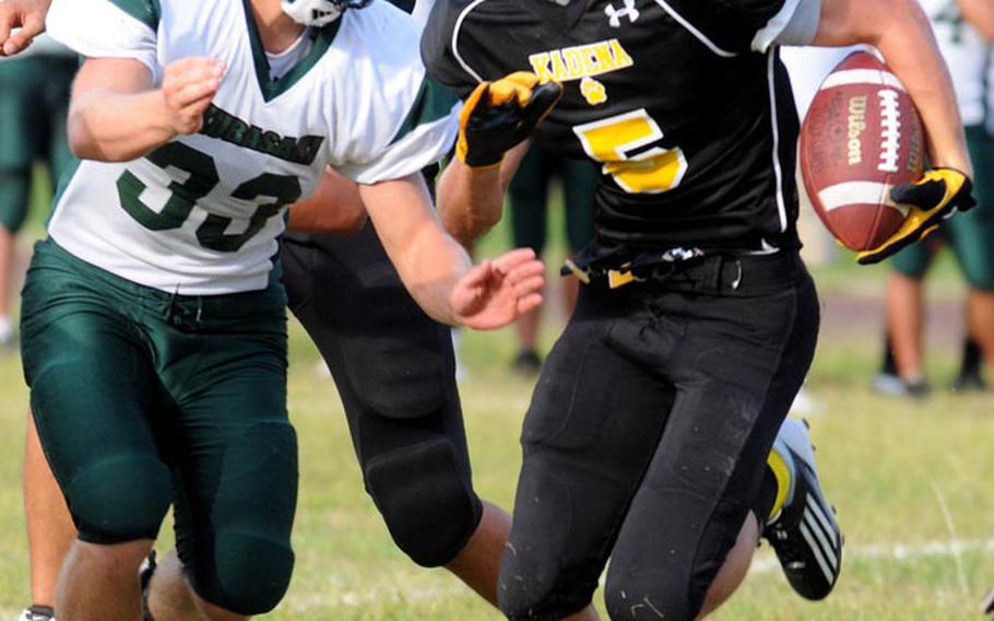 Kadena Panthers running back Justin Sego tries to elude the tackle of Kubasaki Dragons defender Jacob Jadwin during Friday's Okinawa Activities Council football game at Kadena High School, Okinawa. Kubasaki won 13-0, ending Kadena's 15-game winning streak against the Dragons.