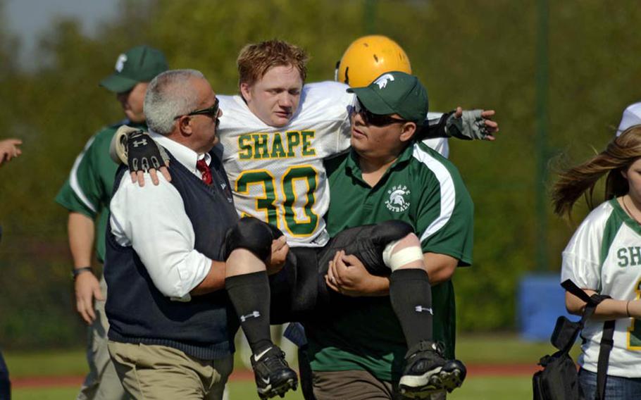 SHAPE's David Brackett is carried off the field after hurting his knee during the Spartans' loss to Bitburg Saturday.