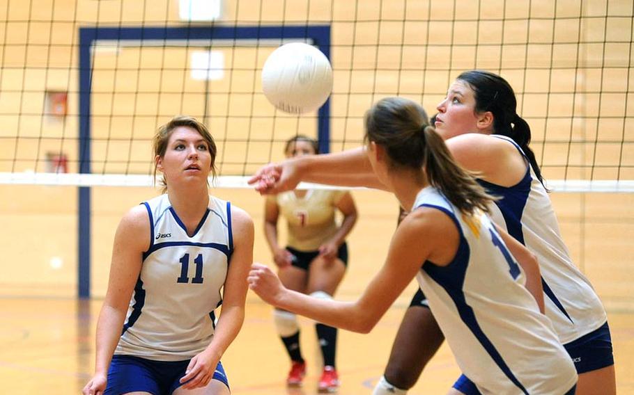 Wiesbaden's Annette Hutzky, right, gets to the ball in front of teammates Kaitlyn Velsaag, left, and Meghan Smith. Wiesbaden dropped their match against defending Division I champ Vilseck, at home Saturday, 19-25, 17-25, 20-25.