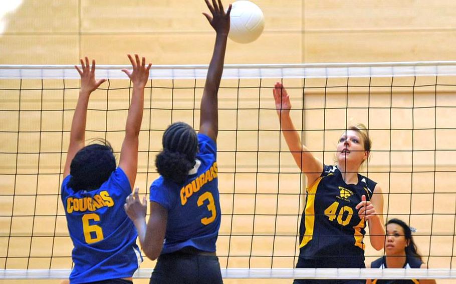Patch's Elizabeth Derner, right, knocks the ball across the net against Ansbach's Jasmine Rodriguez, left, and Jahkaya Smith. Patch won the match in Wiesbaden on Saturday 25-10, 21-25, 25-16, 25-23.