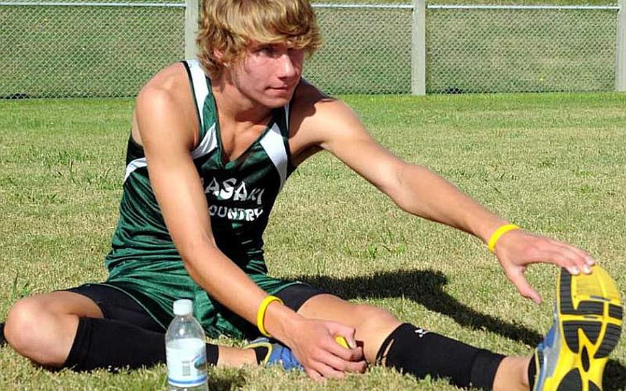 Kubasaki Dragons freshman cross-country runner Erik Armes stretches prior to Wednesday's Okinawa Activities Council meet at Camp Foster, Okinawa. Armes won in 17 minutes, 22 seconds, his fastest time of the season.