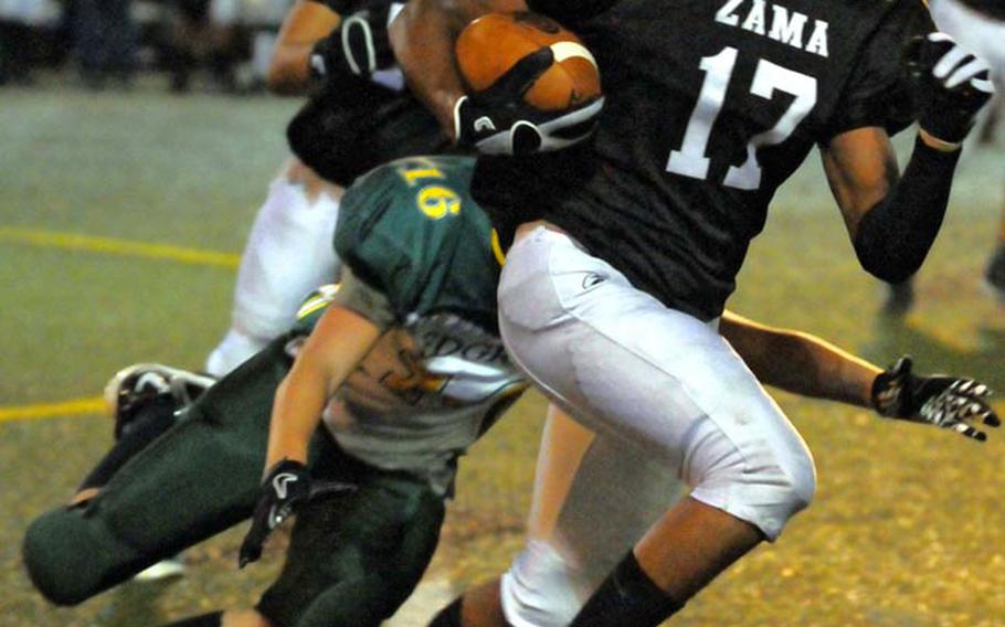 Zama American Trojans running back Mitchell Harrison skirts right end away from Robert D. Edgren Eagles defender Dylan Harris during Friday's DODDS Japan and Far East Division II qualifying game at  Yokosuka Naval Base, Japan. Zama won 41-7, qualifying for its third straight Far East D-II football title game Nov. 5 in Korea.