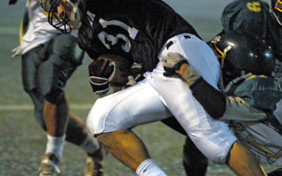 Zama American Trojans fullback Andre Encarnacion tries to elude Robert D. Edgren Eagles defenders Aric Butterfield, James Bowman and Cody Scherrer during Friday's DODDS Japan and Far East Division II qualifying game at Yokosuka Naval Base, Japan. Zama won 41-7, qualifying for its third straight Far East D-II football title game Nov. 5 in Korea.