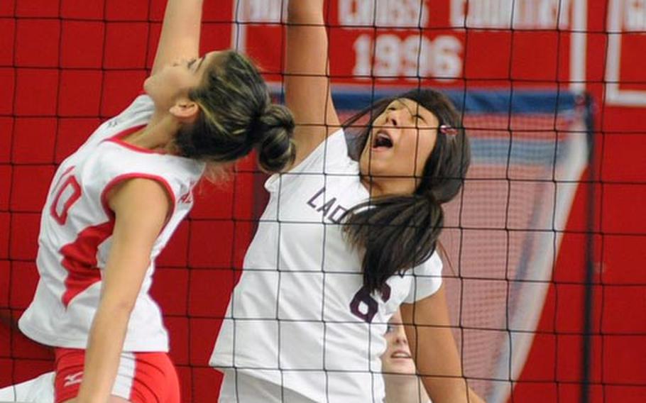 Kaiserslautern's Grace Gonzalez-Flores, left, and Baumholder's Joanna Oviedo battle for the point at the net in high school volleyball action in Kaiserslautern on Saturday. The home team won 25-18, 20-25, 25-11, 25-21.