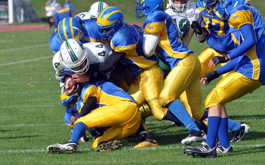 The Ansbach Cougars defense brings down Naples running back Bryan Pfirrmann Saturday in the Wildcats' 41-40 win over the Cougars.