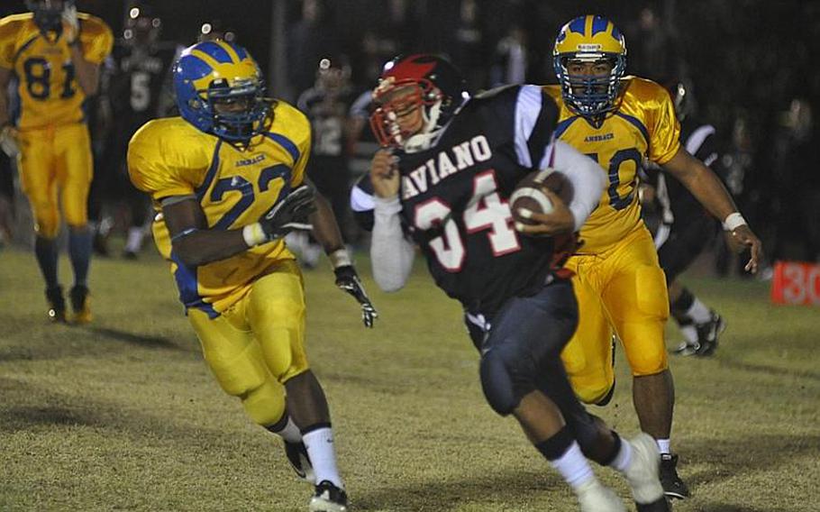 Aviano senior running back Darien Cornett sweeps past Ansbach's DeMar Flake on his way to some of his 167 yards ruhsing. But the Saints lost 70-42.