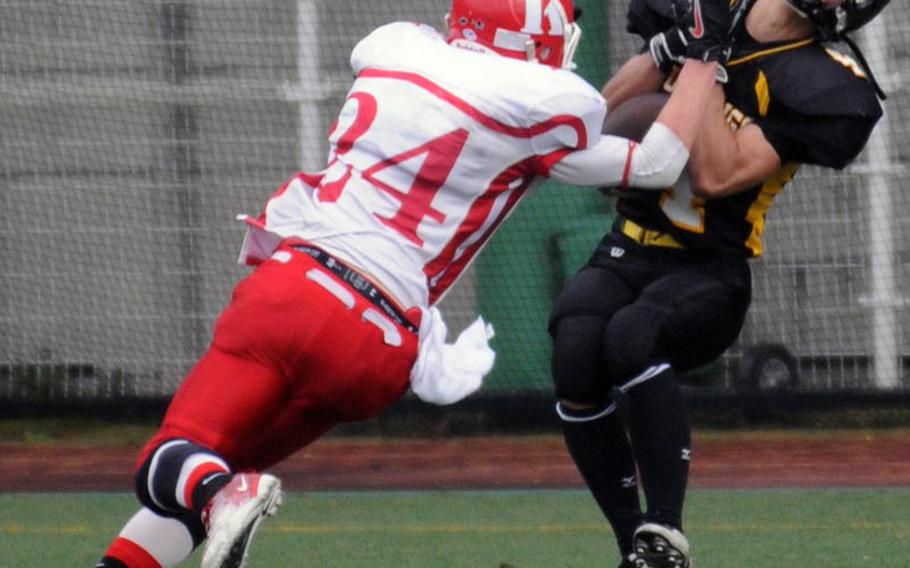 American School In Japan Mustangs receiver Charlie Seno, right, battles for the ball with Nile C. Kinnick Red Devils defensive back Dustin Kimbrell during Saturday's Kanto Plain Association of Secondary Schools football game in Tokyo. ASIJ won 35-6.