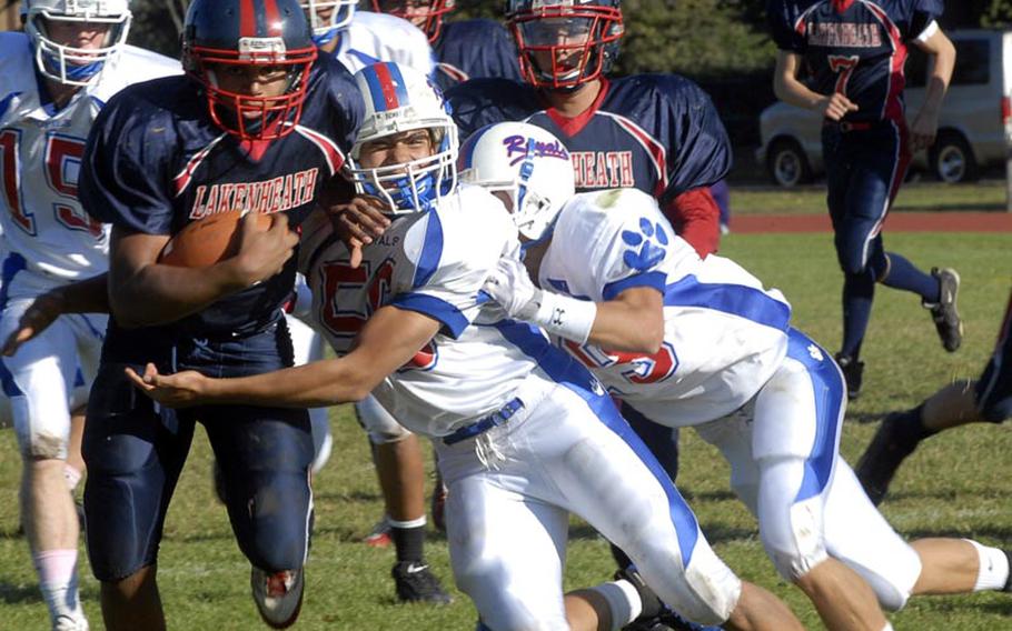 Lakenheath running back Xavier Thompson tries to break free from two Ramstein defenders, Ariel Padilla, center, and Jaap Van Gaalen, right, Saturday in England. The Royals won the contest 13-3. Thompson, a junior, finished with 18 carries for 70 yards.