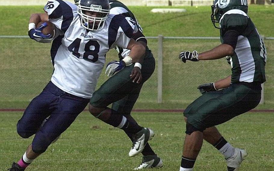 Seoul American running back Alex MdDonald tries to avoid two Kubasaki Dragons defenders during Saturday's Far East High School Division I football semifinal at Kubasaki High School, Okinawa. The Dragons beat the visiting Falcons 22-7.