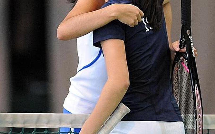 ISB's Haley Tan, foreground hugs Ramstein's Michaella Corral after she and teammate Sayaka Goto beat Corral and Olivia Rockwell 6-2, 6-3 for the girls doubles title at the DODDS-Europe tennis championships.