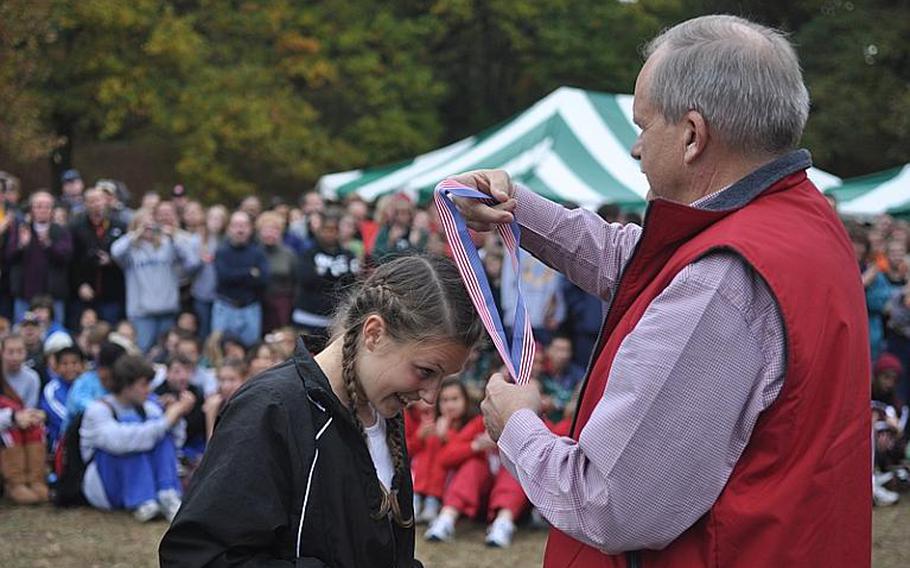 Patch sophomore Baileigh Sessions is awarded the gold medal for finishing first at the 2011 European Cross Country Championships Saturday at the Tompkins Barracks training area in the Heidelberg suburb of Schwetzingen, Germany. Fellow teammate and close friend Morgan Mahlock came in first in all previous races this year but Sessions passed her three quarters through the race.