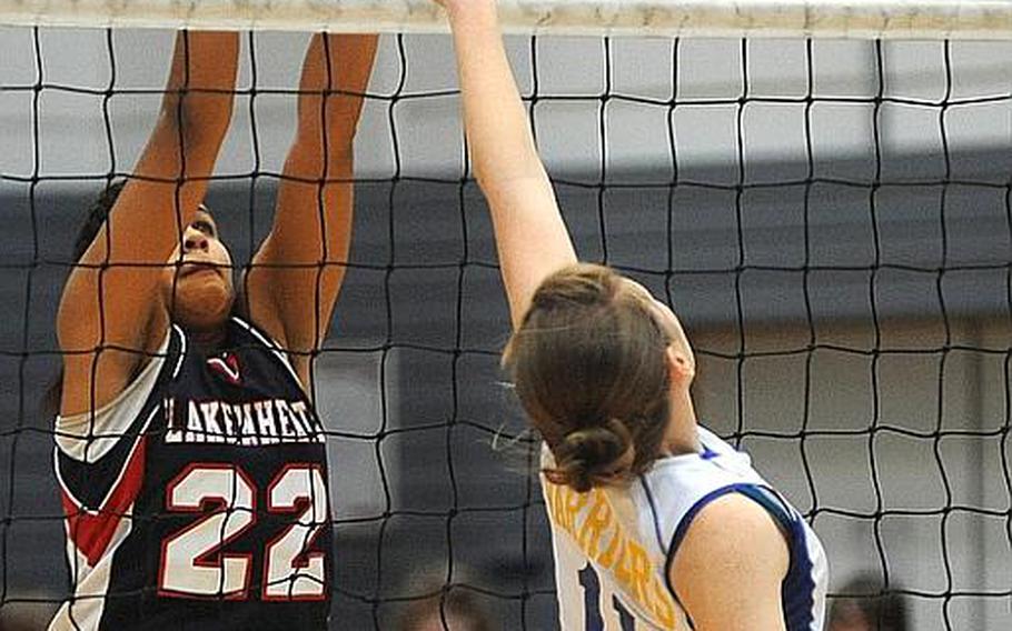 In Division I round-robin action Lakenheath's Jourdan Hodge, left, tries to block a ball from Wiesbaden's Kaitlyn Velsvaag. Wiesbaden won 25-14, 21-25, 25-27.