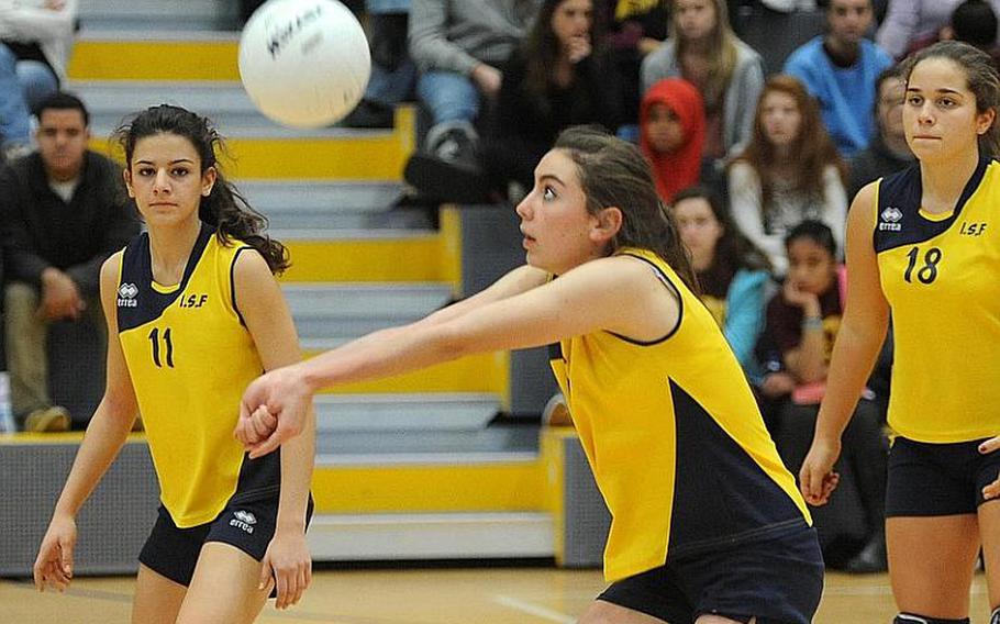 International School of Florence's Alexandra Draime bumps the ball in the Division III final at the DODDS-Europe volleyball finals, as teammates Sofia Vannini, left, and Caterina Sodi watch. Florece fell to defending champion Rota 25-19, 25-13, 25-15 in Ramstein on Saturday.