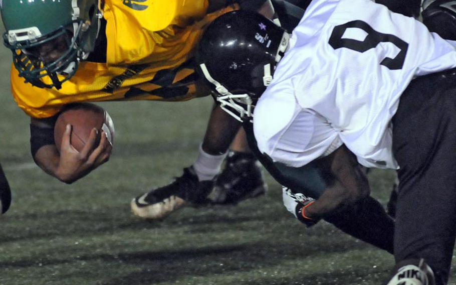 Daegu Warriors running bac Lee Wright is tackled by Zama American Trojans defender Richard Castillo during Saturday's championship game at Camp Walker, South Korea. The Warriors beat the Trojans 7-3.