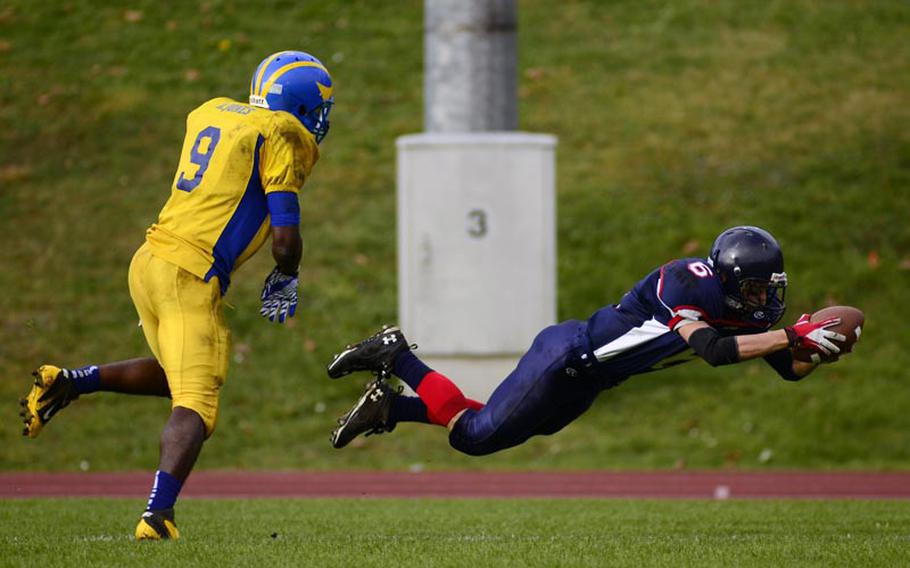 Bitburg's Matt Flood dives for the end zone after a push from Ansbach's Xavier Jones.