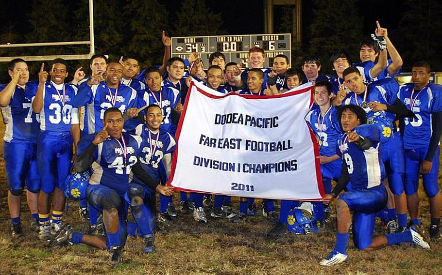 Yokota Panthers players celebrate with the banner after their 34-6 victory Saturday over Kubasaki in the Far East Division I championship game. It was Yokota's first D-I title in school history.