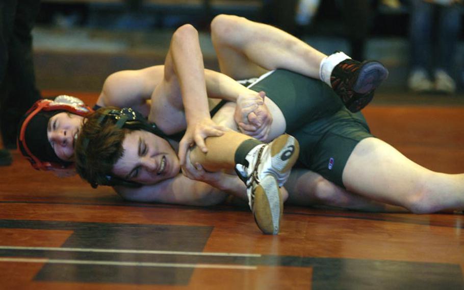 SHAPE's Steven Conkright tries to break free from Lakenheath's Marlon Fouse during a battle in the 126-pound weight class. Conkright, a freshman, defeated Fouse, a sophomore, by a score of 12-5. 