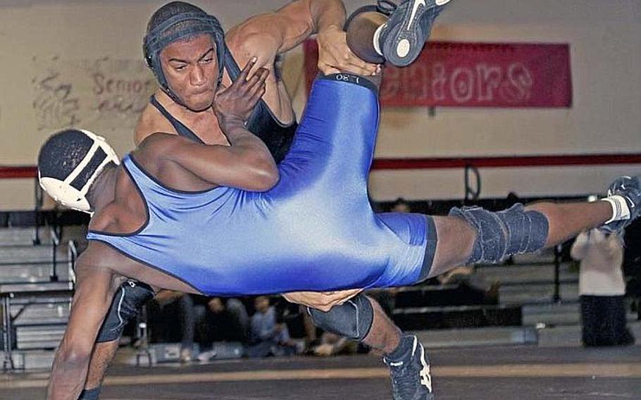 Mitchell Harrison of Zama American sends Jeff Ogutu of St. Mary's International airborne during Wednesday's 180-pound bout in the Kanto Plain Association of Secondary Schools season-opening dual meet for both teams at Zama American High School, Japan. Harrison pinned Ogutu in 1 minute, 55 seconds, but St. Mary's won the dual meet 45-17.