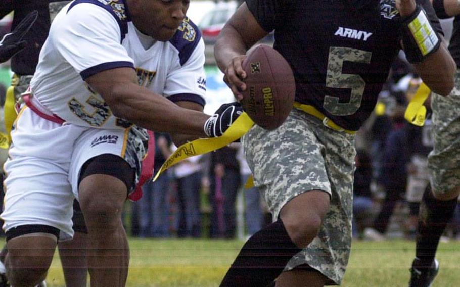 Army quarterback Dean Werner tries to elude the tackle of Navy defender Torey Taylor during Saturday's 22nd Okinawa Army-Navy flag football game at Torii Field, Okinawa. Army rallied from a 21-12 deficit to beat Navy 25-21.