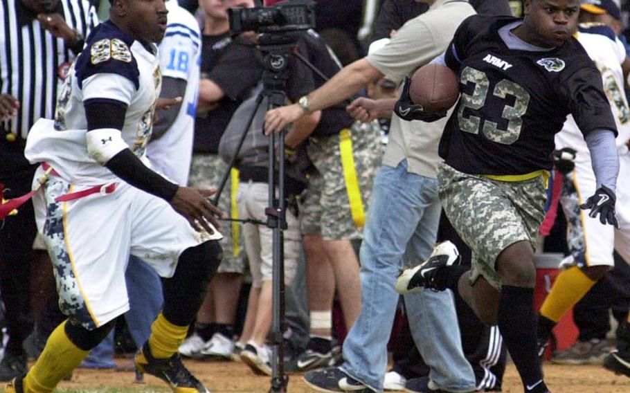 Army running back Joseph Smallwood outruns Navy defensive end Tyron Francis during Saturday's 22nd Okinawa Army-Navy flag football rivalry game at Torii Field, Torii Station, Okinawa. Army rallied from a 21-12 deficit to beat Navy 25-21. Smallwood was named the game's Offensive Most Valuable Player.